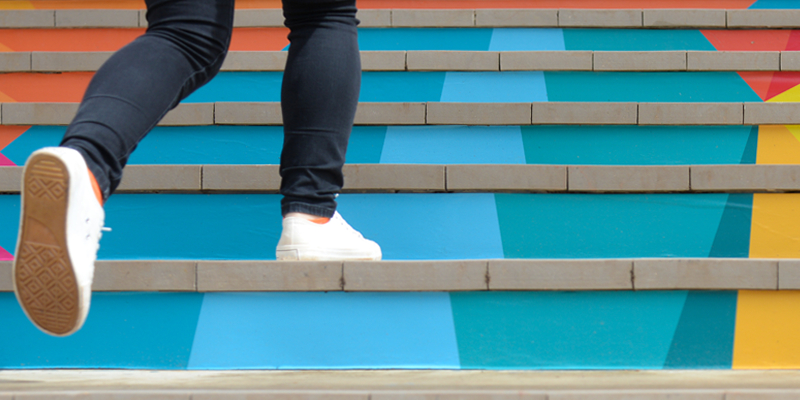 Une personne montant sur des escaliers en couleurs